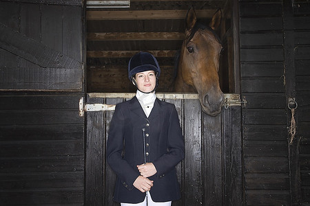 女骑手摄影照片_女骑手在马厩中的肖像
