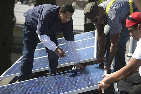 一群人抬起一块巨大的太阳能电池板