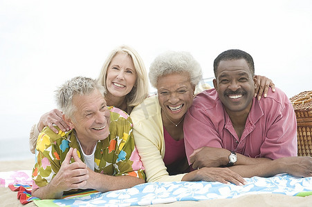 四个高年级的朋友趴在沙滩上老年人人物特写