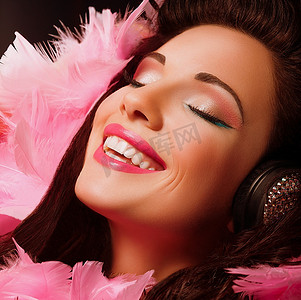 仁爱摄影照片_灵感。粉色羽毛的花式开朗快乐的女人微笑着。快乐
