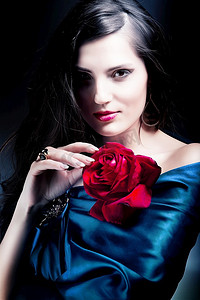 穿着蓝色面料，戴着红玫瑰的美女