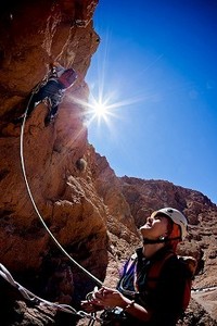 摄影照片_在非洲马鲁克阿特拉斯的托德拉山谷，一名女登山者在攀岩中保护着领队。