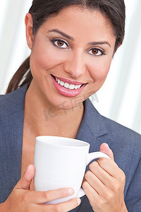 年轻漂亮的拉美裔女性或商界女性面带微笑，悠闲地喝着茶或咖啡