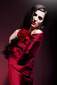 穿着红色面料，戴着红玫瑰的美女