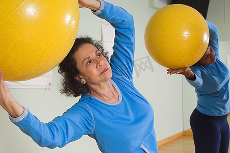 健身课上使用健身球的老年女性