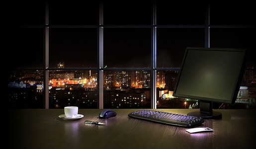 晚上在办公室的工作场所,从窗户可以看到城市的景色夜景摄影吸顶灯