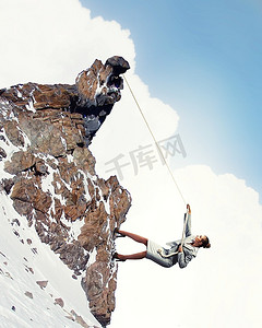 女商人攀登雪山陡峭的山挂在绳子