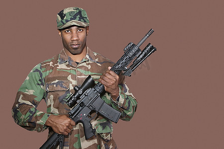 军队展板摄影照片_美国海军陆战队非裔美国士兵在棕色背景下手持M4突击步枪的肖像
