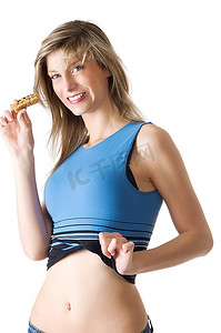穿着蓝色衬衫的金发女孩吃着减肥片，在镜头前微笑
