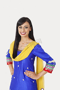 穿着传统服装、双手抱臀站在灰色背景上的印度美女肖像