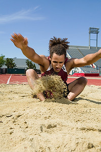 男子跳远运动员在沙坑落地