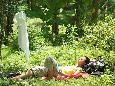 一名年轻女子躺在热带森林里晒日光浴