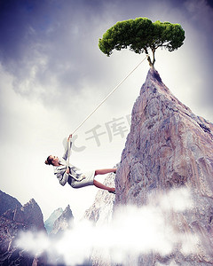 女商人攀登陡峭的山峰，树顶挂在绳子上