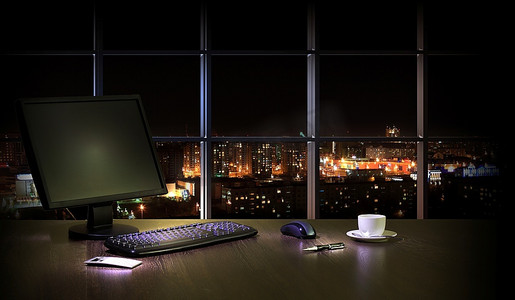 晚上在办公室工作，从窗户可以看到城市的景色