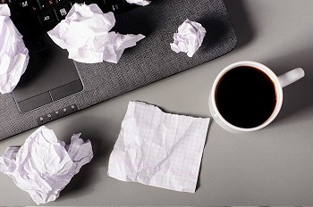 商业创意概念。笔记本电脑、纸张和皱巴巴的纸团放在桌子上。