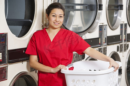 快乐年轻女员工携带洗衣篮与洗衣机家庭清洁日常场景