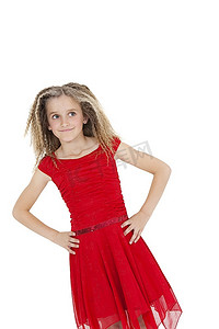 穿着红色连衣裙的女孩手放在臀部的倾斜图像覆盖着白色背景