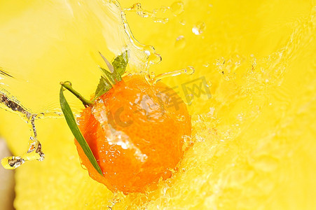 黄色液体摄影照片_橘子和水溅在黄色上，特写