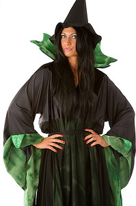 黑绿背景摄影照片_一位身穿黑绿相间连衣裙，头戴帽子的美丽女巫