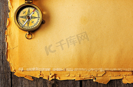 古董黄铜指南针在旧纸背景