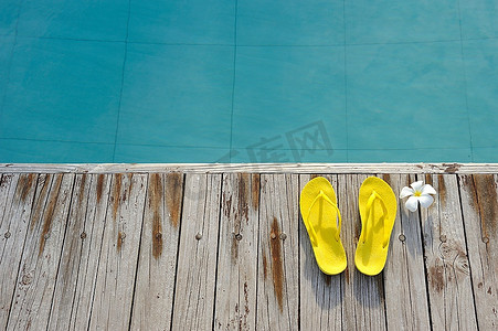 游泳池边的黄色凉鞋