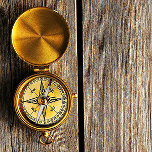 木质背景的古董黄铜指南针