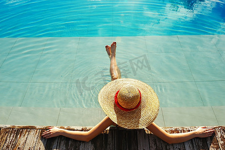 水谭摄影照片_妇女在帽子放松在游泳池