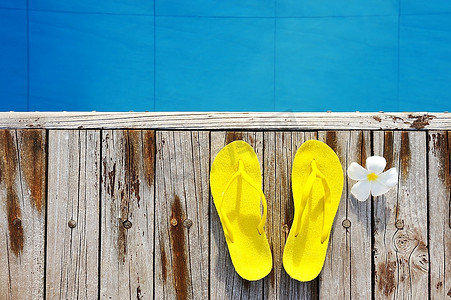 游泳池边的黄色凉鞋