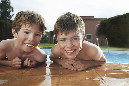 两个男孩(6-11岁)靠在泳池边的肖像