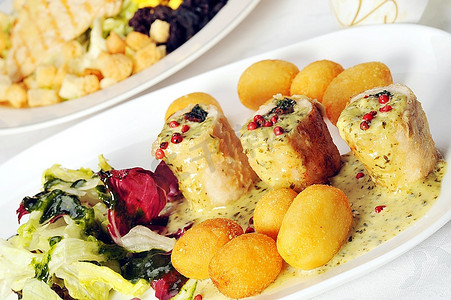 土耳其烤肉摄影照片_餐桌上有肉类沙拉和热熟的火鸡肉。在餐厅用餐