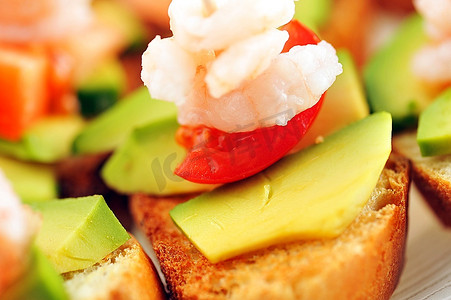 点缀绿色摄影照片_点缀着虾、鳄梨和生菜的三明治，小吃