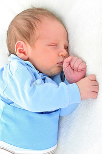 睡在白色毯子上的新生可爱的婴儿