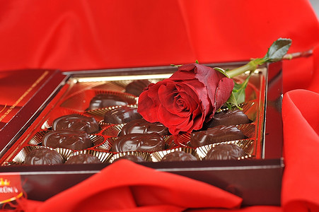 金箔盒，各种巧克力和玫瑰色，红色背景
