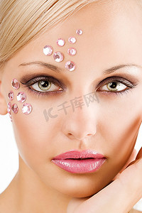 水晶石摄影照片_美女特写：一位脸上镶着粉色水晶石的年轻漂亮女子