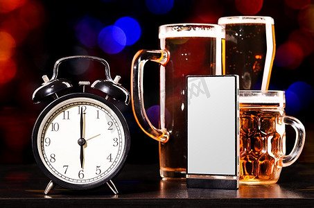 喝啤酒的时间到了。一杯带闹钟和手机的新鲜啤酒