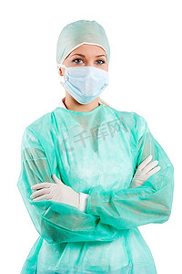 年轻的美容护士穿着绿色手术服，戴着手术帽和口罩摆姿势