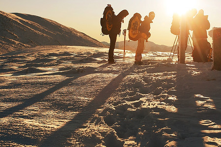 冬天装备摄影照片_在冬天的山上徒步旅行