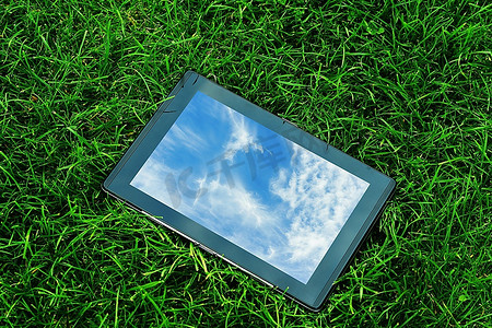 通用背景摄影照片_绿草上的通用平板电脑(Tablet PC)