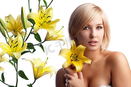 经典的美女肖像，年轻而美丽的女人，金发裸露的肩膀上举着一朵黄色的百合花，覆盖着白色