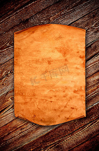 在陈旧木材的背景下有卷曲边缘的空白旧纸