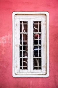 旧的红色粉刷墙背景上的白色窗户