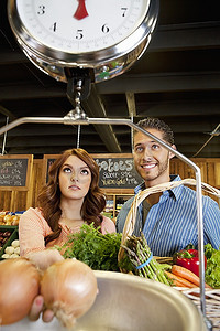 幸福的年轻夫妇在超市里看体重秤
