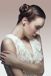 化妆品浪漫摄影照片_身穿白色蕾丝衬衫，留着优雅创意发型的漂亮黑发美女摆出浪漫姿势