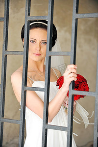 手持玫瑰花的新娘代表着一堵古老的墙