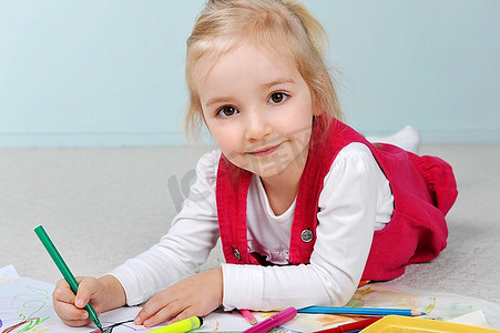 美丽的小女孩在纸上画画