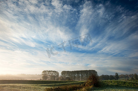 秋天的风景穿过雾蒙蒙的冰冷的田野走向日出