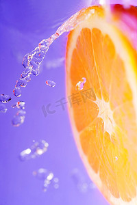 明亮多汁的橙色，在紫色的背景上飞溅