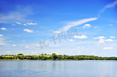 平静的湖水，对岸的树林，蔚蓝的天空。景观