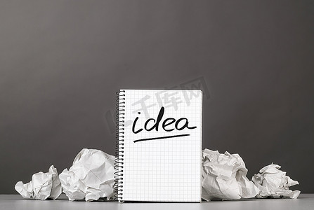 创造性的过程。皱巴巴的纸巾和印有Word Idea的笔记本