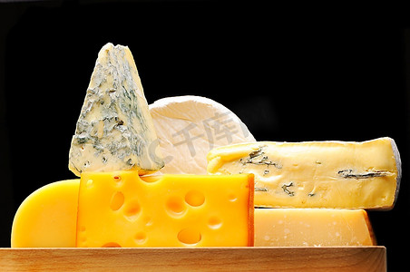 奶酪png摄影照片_各种类型的奶酪覆盖在黑色之上